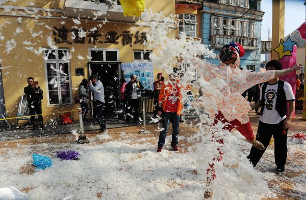  People take part in a pillow fight at a park in Changsha, Hunan province, on March 7, the eve of the International Women's Day. The event was organized as relaxation for the participants, especialy females. [Photo/Asianesphoto]