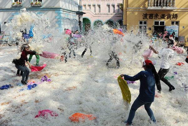  People take part in a pillow fight at a park in Changsha, Hunan province, on March 7, the eve of the International Women's Day. The event was organized as relaxation for the participants, especialy females. [Photo/Asianesphoto]