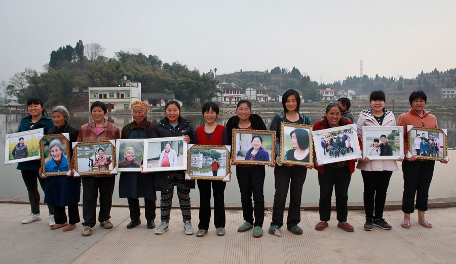 A group of rural women whose husbands work outside the village hold up their portraits taken by local photographers to mark International Women's Day, March 6, 2013, in Zhengzi village, Southwest China's Sichuan province. [Photo/Asianewsphoto]