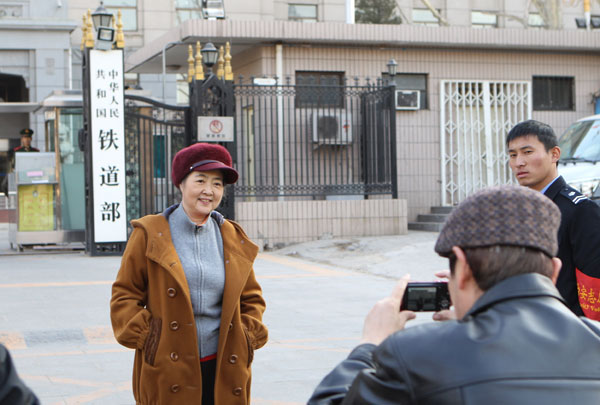 Staff members take photographs at the entrance of the Ministry of Railways, which will be dissolved.[ Photo/ China Daily]
