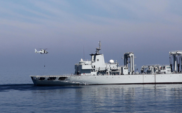 A carrier-based helicopter flies commandoes to a “hijacked” commercial ship, which is played by the supply ship Weishanhu, during a combat rescue drill of China’s 14th escort fleet on March 10 in the Arabian Sea. [Photo/Xinhua]