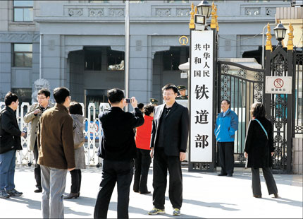 People take photographs outside the gate of the Ministry of Railways Sunday with the ministry sign in the background on the day that the central government unveiled its decision to dismantle the once powerful ministry. [Shanghai Daily]