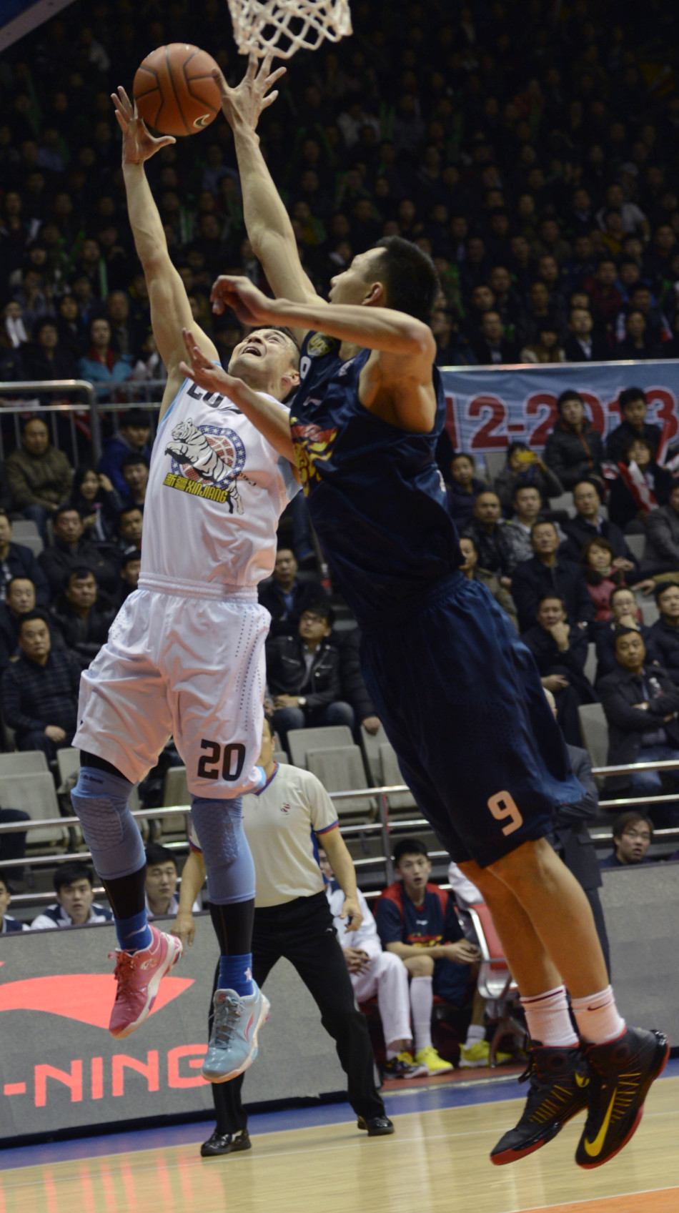 Yi Jianlian tries to block Xi Relijiang's shot in Game 1 of CBA semifinals between Guangdong and Xinjiang on March 10, 2013.