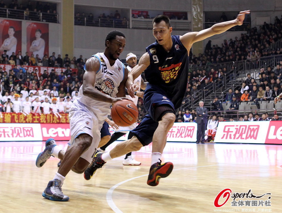 Von Wafer of Xinjiang tries to drive past Yi Jianlian in Game 1 of CBA semifinals between Guangdong and Xinjiang on March 10, 2013.