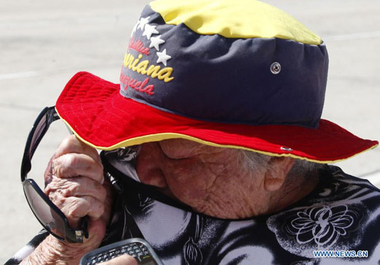 A resident reacts as he waits in the Proceres Avenue to enter the Military Academy of Venezuela to say his last goodbye to President Hugo Chavez, in the city of Caracas, capital of Venezuela, on March 9, 2013. [Xinhua Photo]