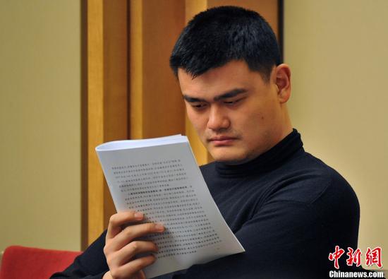 Yao Ming, a member of China's top political advisory body, the Chinese People's Political Consultative Conference, carefully reads the Government Work Report delivered by Premier Wen Jiabao at the First Session of 12th National People's Congress on March 5, 2013.