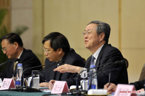 Zhou Xiaochuan (1st R), China's central bank governor, speaks at a news conference on China's currency policy and financial reform held by the first session of the 12th National People's Congress (NPC) in Beijing, capital of China, March 13, 2013. (Xinhua
