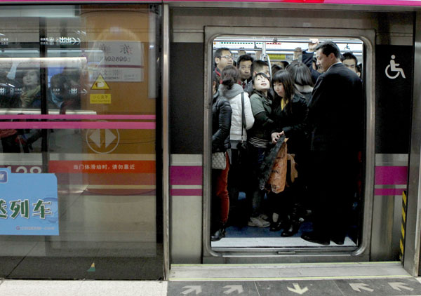 Passengers in a crowded carriage at Dongdan station on the Beijing Subway's Line 5 on Wednesday. The average daily passenger volume for subway lines in early March was 8.4 million. [Photo/China Daily]