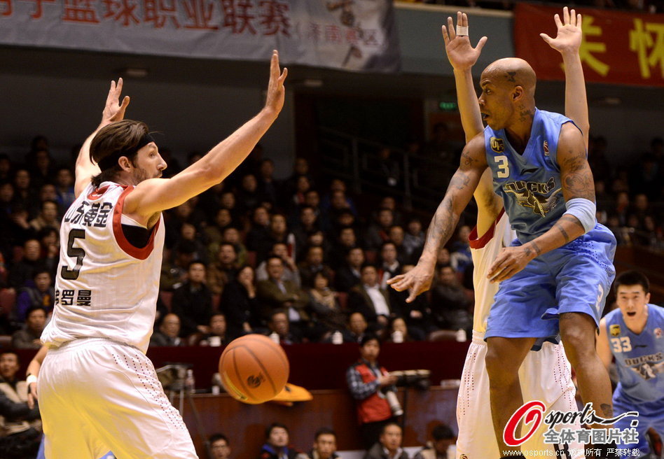 Stephon Marbury of Beijing passes the ball in front of defenders in CBA semi-final clash between Shandong and Beijing on March 13, 2013. 