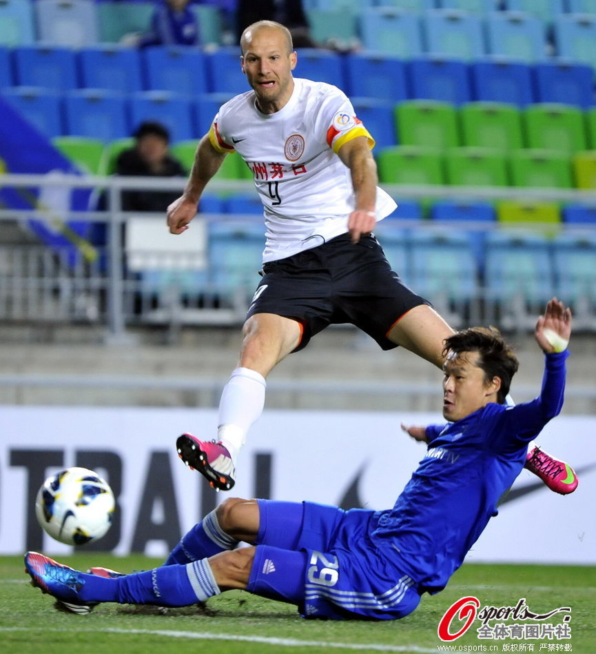 Kwak Hee-Ju of Suwon Bluewings tries to stop Renhe's Muslimovic. 