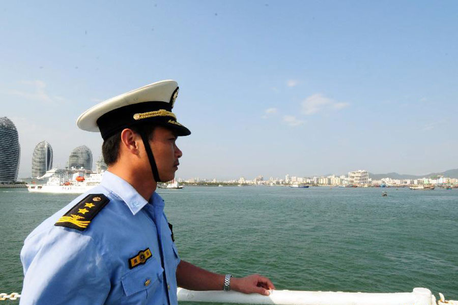 The commander of the Haijian 263 ship of China Marine Surveillance (CMS) detachement observes at the bow before the ship anchors the Sanya Harbor of south China's Hainan Province, March 14, 2013.