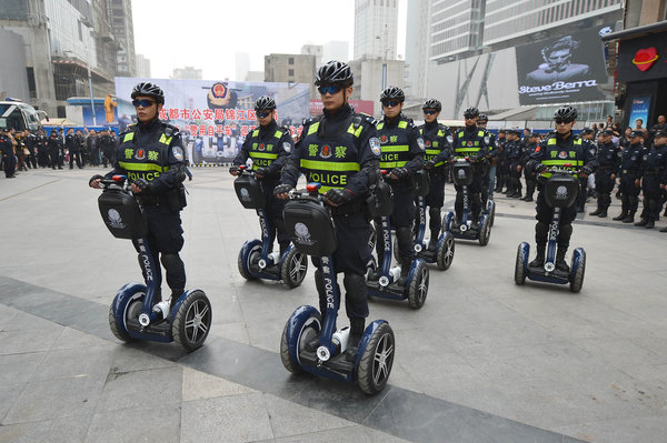 Policemen on electric vehicles patrol a walking street in Chengdu, Southwest China's Sichuan province, March 14, 2013. 