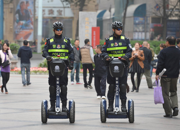 Policemen on new electric vehicles patrol Chunxi walking street in Chengdu, March 14, 2013. [Photo/CFP] 