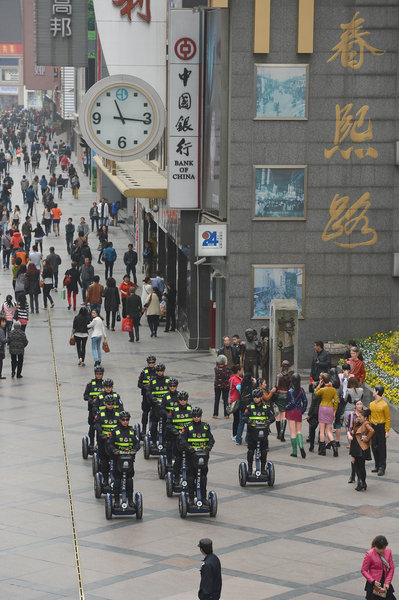 Ten policemen patrol Chunxi Road, a walking street in Chengdu, on electric vehicles, March 14, 2013. [Photo/CFP] 