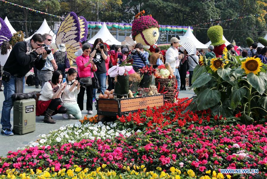 People take pictures of flowers displayed at a flower show in south China's Hong Kong, March 15, 2013. The 10-day Hong Kong Flower Show 2013 kicks off on Friday at Victoria Park. More than 200 organizations contributed some 350,000 flowers to the show. [Photo / Xinuha]