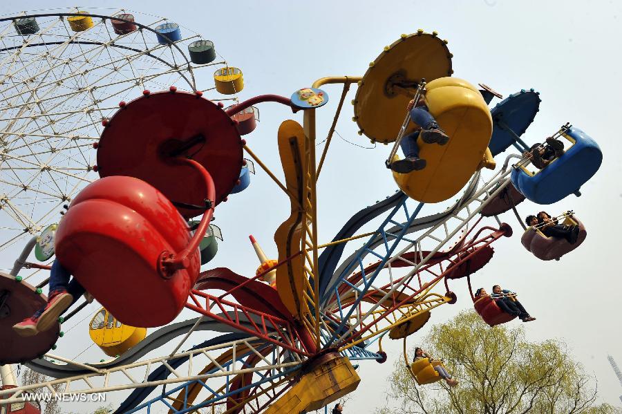 Citizens play at an amusement park during the early Spring in Jinan City, capital of east China&apos;s Shandong Province, March 16, 2013. 