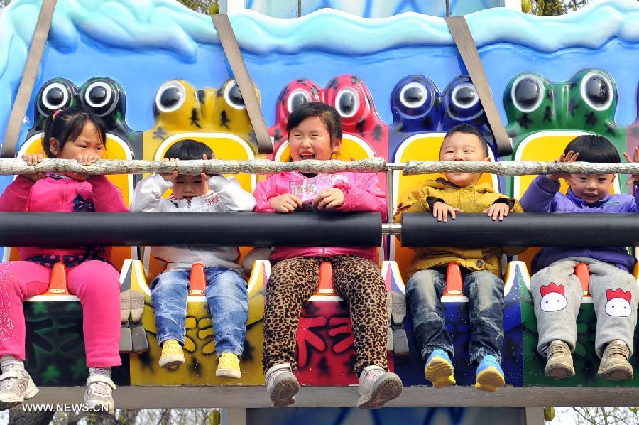 Children play at an amusement park during the early Spring in Jinan City, capital of east China&apos;s Shandong Province, March 16, 2013.