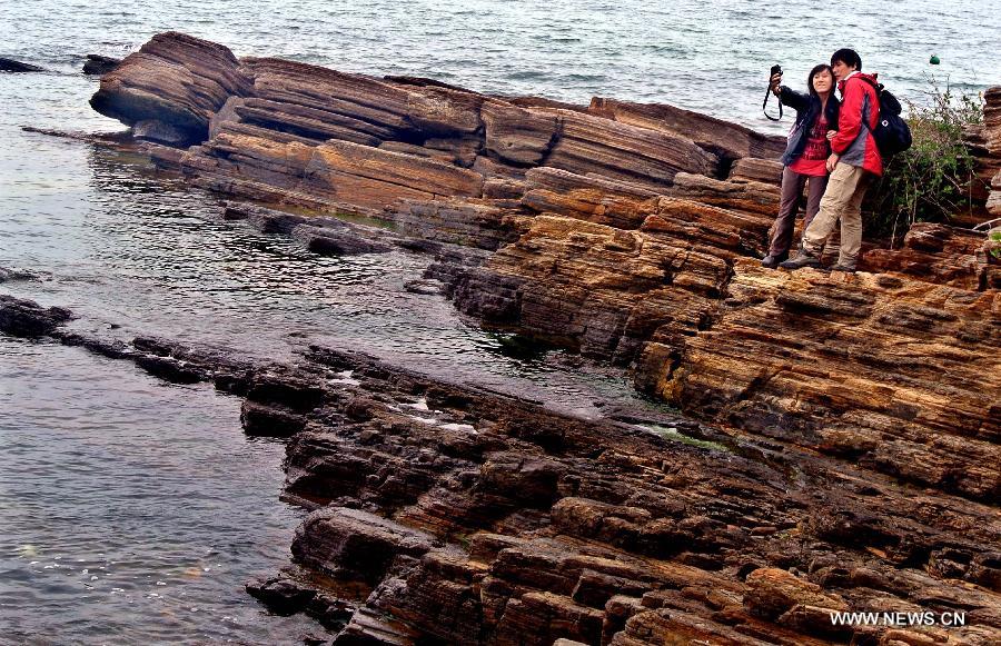 A couple take photos of themselves on the Tung Ping Chau island of south China's Hong Kong, March 17, 2013. 