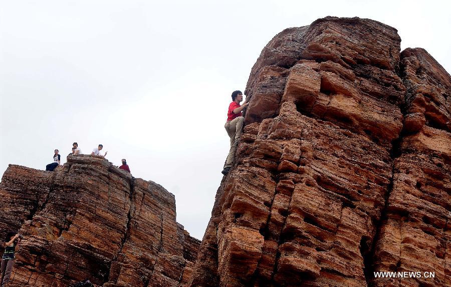 A tourist climbs up a shale rock on the Tung Ping Chau island of south China's Hong Kong, March 17, 2013. Tung Ping Chau lies in the northeast corner of Hong Kong and is part of the Hong Kong Geopark. 