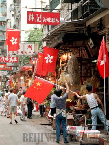 Hong Kong residents hoist the flags of China and Hong Kong Special Administrative Region side by side on July 1, 1997, in celebration of the region's return to China [Xinhua photo] 