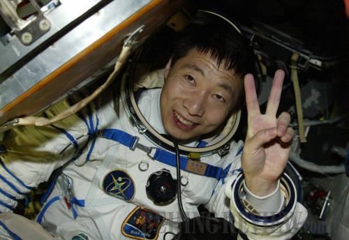 Astronaut Yang Liwei greets crew and onlookers as he emerges from the return capsule of theShenzhou-5, China's first manned space vehicle, on October 16, 2003 [Xinhua photo]