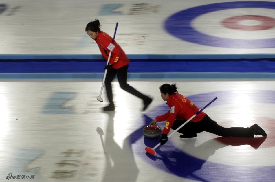 China's third Liu Yin (R) delivers a stone during their World Women's Curling Championship qualification round match against Sweden in Riga, March 19, 2013. 