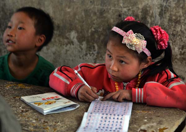A girl attends a class at a rural school in Bijie, Guizhou province. China's education authority said the country will make more efforts to improve fairness in education. [Photo/China Daily]