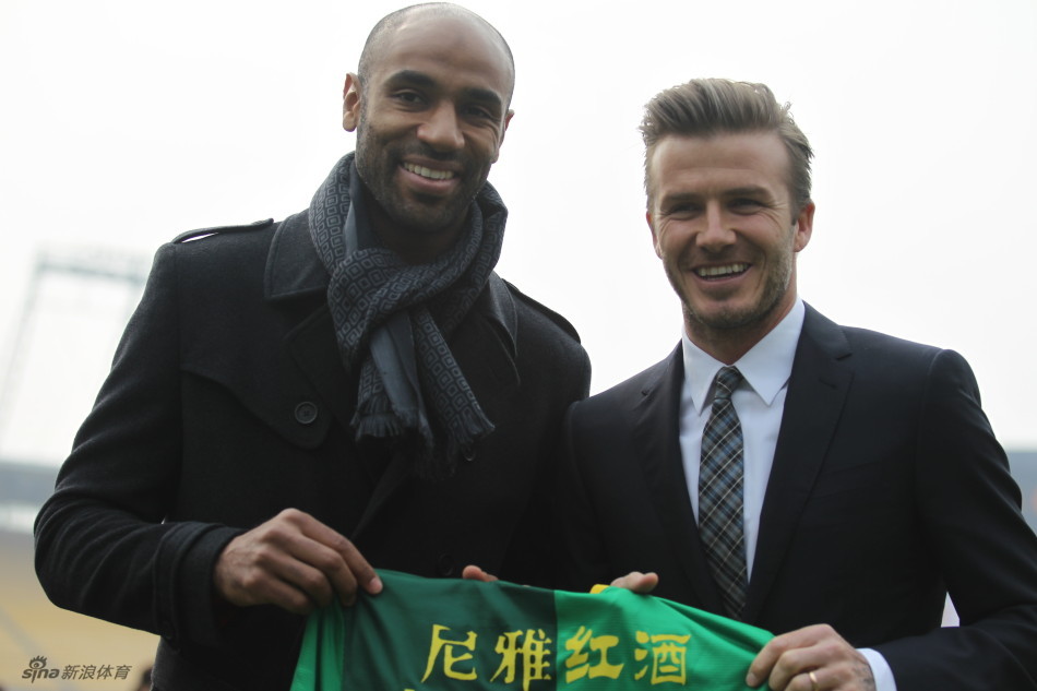 David Beckham takes a picture with Beijing Guoan's Kanoute.
