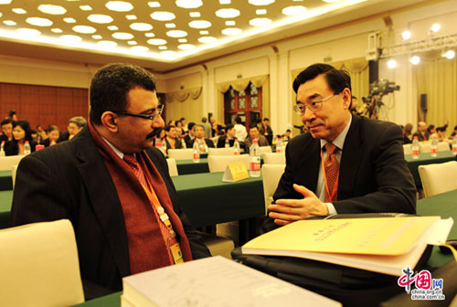 Vice president of China International Publishing Group (CIPG) Huang Youyi(R) talks with a Egyptian scholar at the Fifth World Forum on China Studies in Shanghai, March 23, 2013