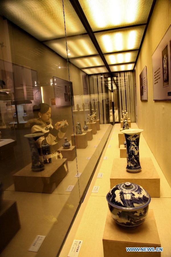 A visitor takes photos of porcelain wares at a Japanese Imari porcelain exhibition in Hohhot, capital of north China's Inner Mongolia Autonomous Region, March 27, 2013.