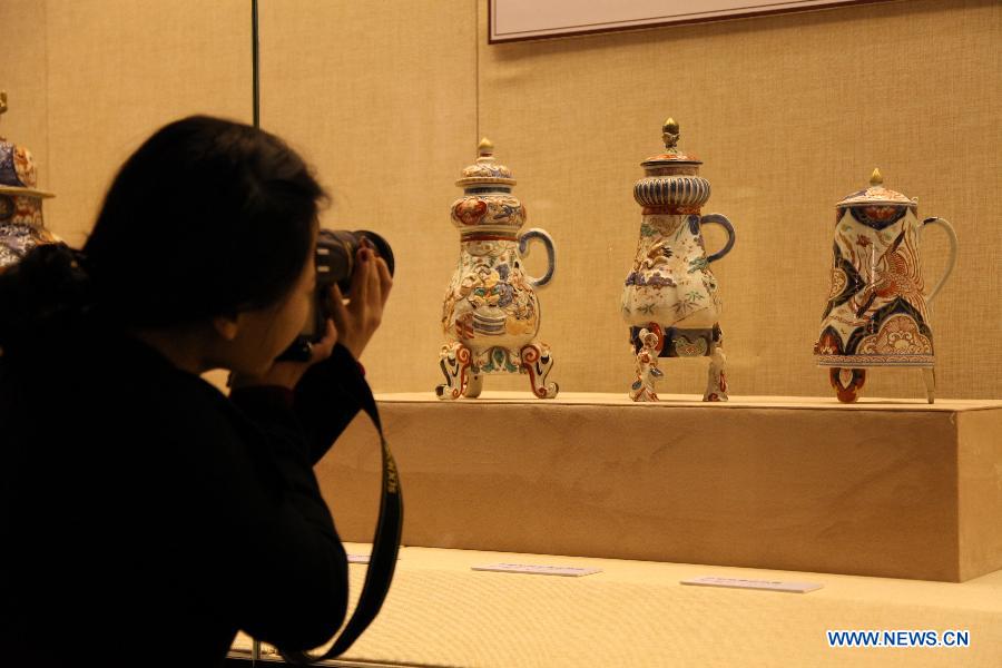 A visitor takes photos of porcelain wares at a Japanese Imari porcelain exhibition in Hohhot, capital of north China's Inner Mongolia Autonomous Region, March 27, 2013. 