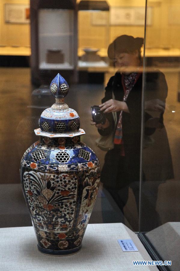 A visitor takes photos of a porcelain ware at a Japanese Imari porcelain exhibition in Hohhot, capital of north China's Inner Mongolia Autonomous Region, March 27, 2013. 