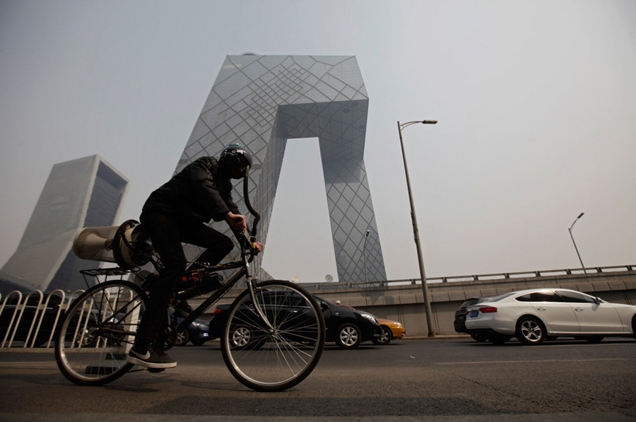3月26日，北京，英国艺术家麦特•霍普骑着他自制的“会呼吸的自行车”行进在东三环央视新台址附近。[腾讯网]