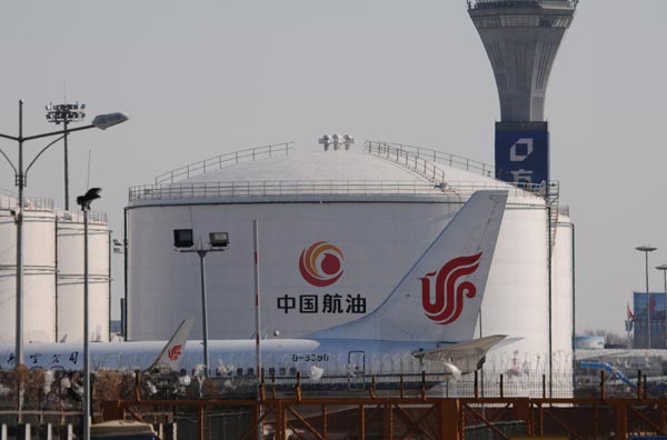 An Air China aircraft next to an oil depot. Fuel costs accounted for 44.12 percent of Air China's operational costs, while the percentage for China Southern stood at 44.2 percent. [Photo/China Daily]    
