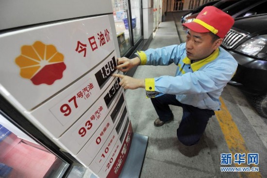 A staff worker adjusts the price notice board in a gas station in Yinchuan, Ningxia Hui Autonomous Region, on March 27, 2013. 
