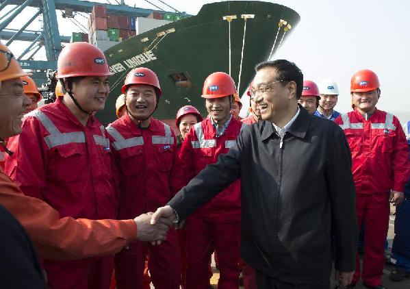 Photo taken on March 28, 2013 shows Chinese Premier Li Keqiang (R, front), also a member of the Standing Committee of the Political Bureau of the Communist Party of China (CPC) Central Committee, visits workers at Waigaoqiao international container port in east China's Shanghai Municipality. Li had a research tour to Jiangsu and Shanghai from March 27 to March 29. [Li Xueren/Xinhua]