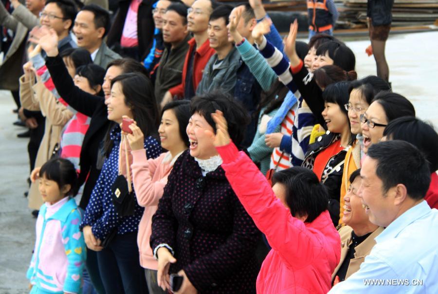 Family members of crew members on Chinese fishery patrol ship 44608 cheer for their return at Yuzheng port in Shantou, south China's Guangdong Province, March 30, 2013. The patrol ship 44608 finished its 23-day patrol cruise around Huangyan Islands on Saturday and returned to Shantou. [Yao Jun/Xinhua]