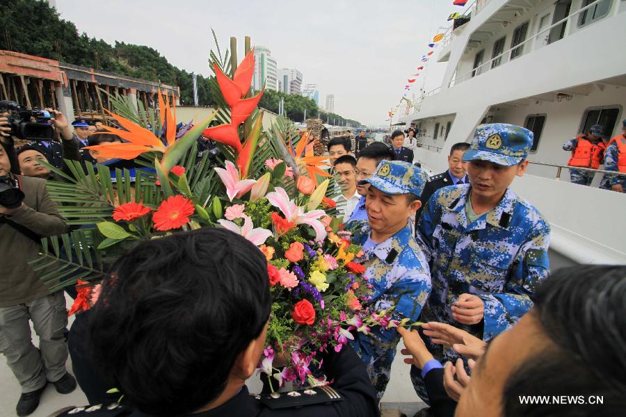 People send flowers to crew members on Chinese fishery patrol ship 44608 for their return at Yuzheng port in Shantou, south China's Guangdong Province, March 30, 2013. The patrol ship 44608 finished its 23-day patrol cruise around Huangyan Islands on Saturday and returned to Shantou. [Yao Jun/Xinhua]