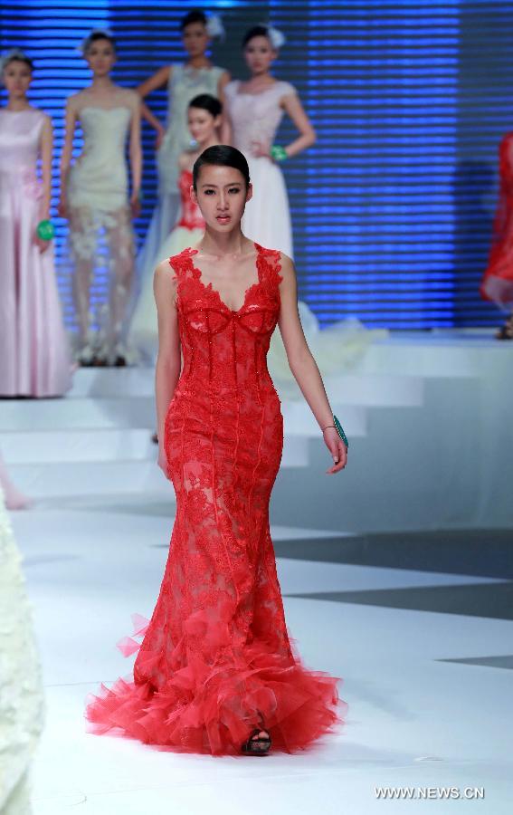 A contestant presents a wedding dress during the 8th China Super Model Final Contest in Beijing, capital of China, March 30, 2013. [Xinhua]