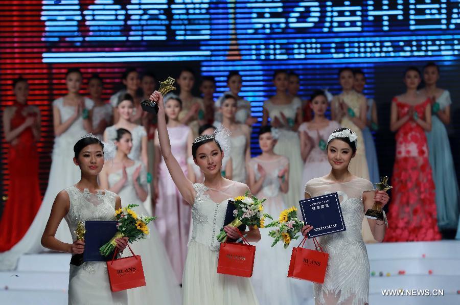 Champion Zhang Lingyue (C), runner-up Zhao Siyu (L) and second runner-up Lei Shuhan greet the audience during the 8th China Super Model Final Contest in Beijing, capital of China, March 30, 2013. [Xinhua]