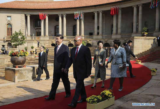 Visiting Chinese President Xi Jinping (front, L) and his wife Peng Liyuan, accompanied by South African President Jacob Zuma (front R) and his wife Bongi Ngema, walk during a welcome ceremony held for his state visit, in Pretoria, South Africa, March 26, 2013. [Xinhua] 