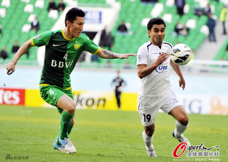 Zhou Ting of Beijing Guoan and Jasur Hasanov of Bunyodkor run for the ball a AFC Champions League Group G match on April 2, 2013. 