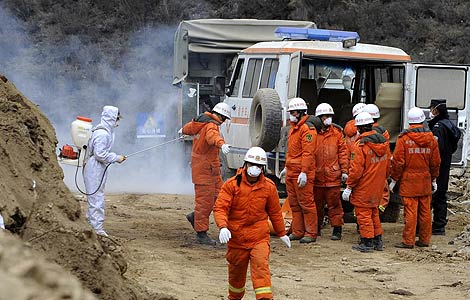 Rescuers disinfect the site of a huge landslide in the Tibet autonomous region, April 2, 2013. [Photo/Xinhua]