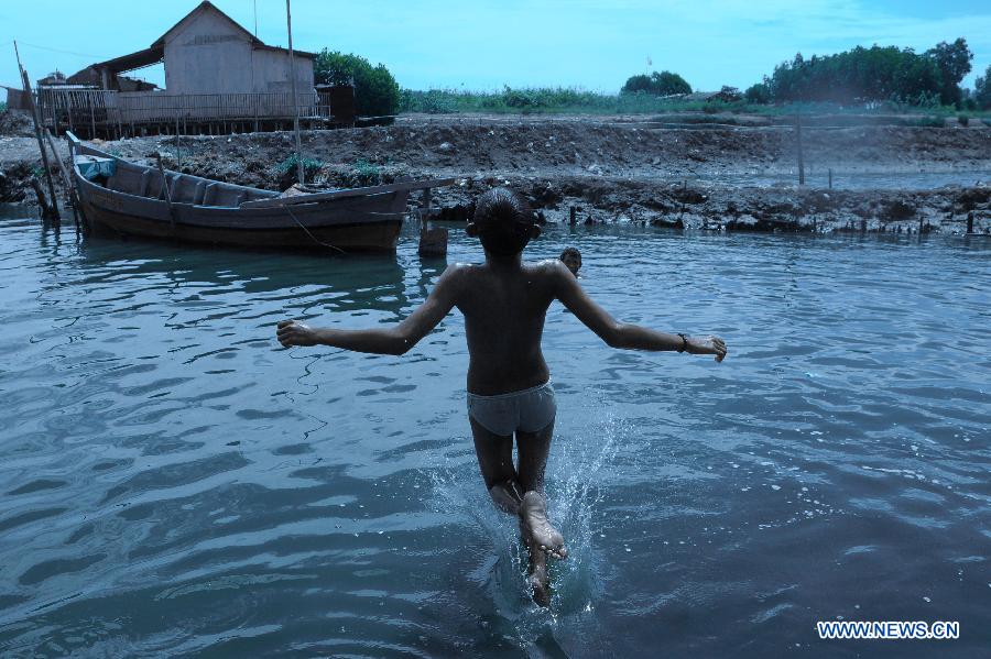 An Indonesian boy jumps into water as he and others play in a river at a slum in Bekasi, West Java Province, Indonesia, on April 8, 2013.