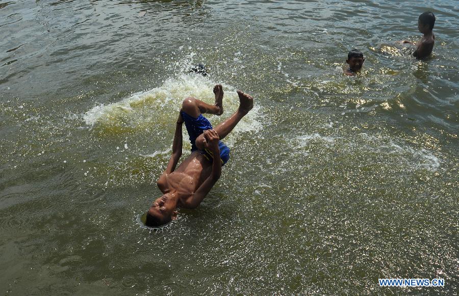 An Indonesian boy jumps into water as he and others play in a river at a slum in Bekasi, West Java Province, Indonesia, on April 8, 2013.