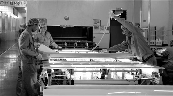 Workers assemble solar panels at Wuxi Suntech, which defaulted on a $541 million bond repayment in March, in Jiangsu province. Experts say that a possible acquisition by Warren Buffett is very likely due to the billionaire's investment habits and would be a win-win situation. [China Daily]