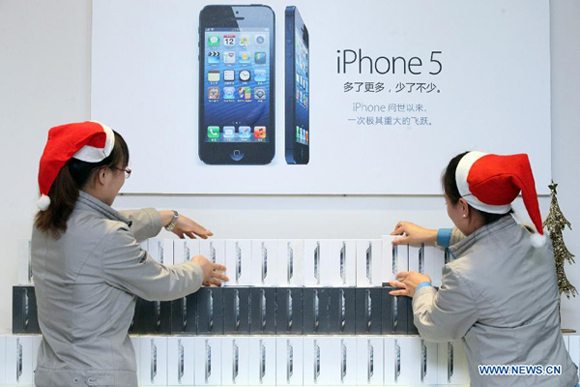 Salespersons count the number of iPhone 5 cell phones to be sold in Binhai New Area in Tianjin, north China, Dec. 13, 2012.[Xinhua]