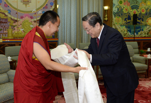 Yu Zhengsheng (R), a member of the Standing Committee of the Political Bureau of the Communist Party of China Central Committee and chairman of the National Committee of the Chinese People's Political Consultative Conference (CPPCC), receives a piece of hada presented by the 11th Panchen Lama Bainqen Erdini Qoigyijabu during their meeting in Beijing, capital of China, April 12, 2013. (Xinhua/Ma Zhancheng)