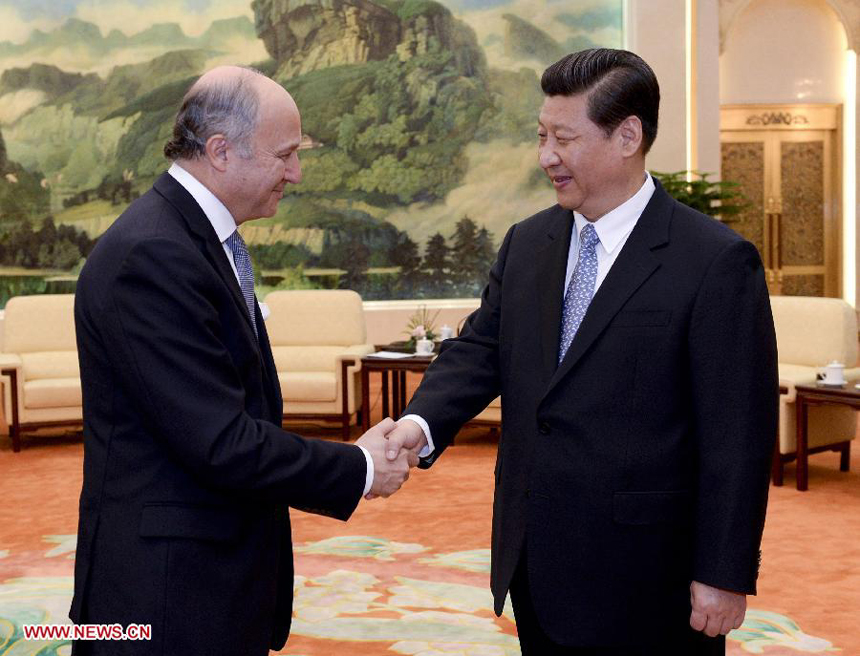 Chinese President Xi Jinping (R) shakes hands with French Foreign Minister Laurent Fabius during their meeting in Beijing, capital of China, April 12, 2013. 