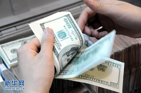 A worker counts US dollars in a Nanchong branch bank in Sichuan Province under the Bank of China on March 25, 2013. The U.S. Treasury Department on April 12, 2013 refused to name China as a currency manipulator, saying it would closely monitor the pace of appreciation of RMB. 